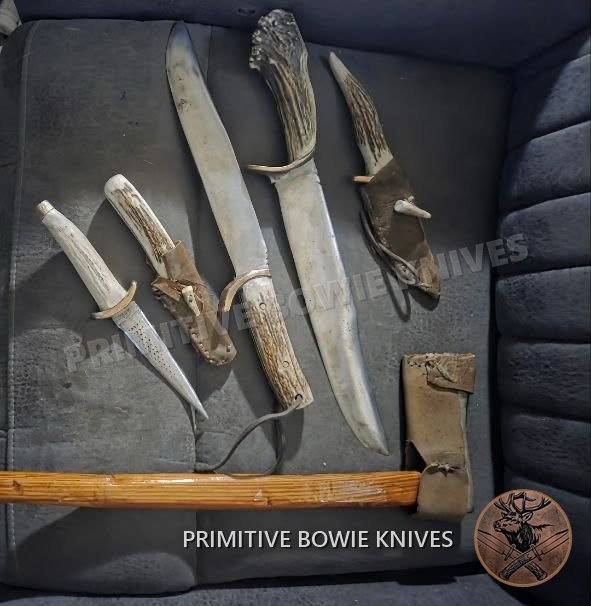 Several stag-handled knives of different sizes laid out together